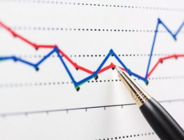 pen pointing to line graph on paper